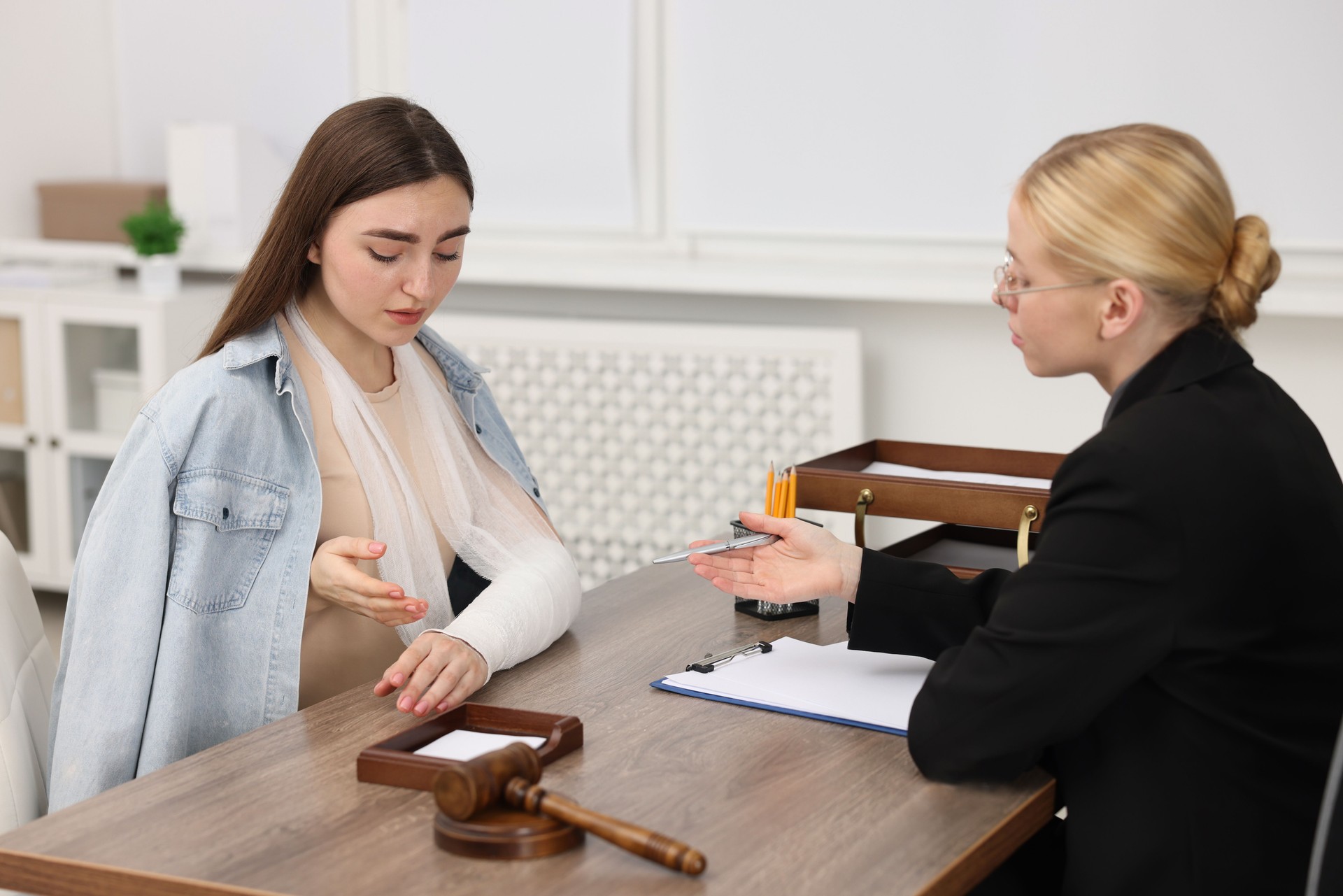 Injured woman having meeting with lawyer in office